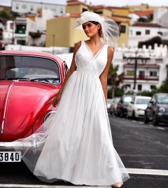 Длинное простое белое свадебное платье с декольте и легкой юбкой