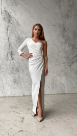 Белое длинное облегающее платье с одним рукавом и разрезом по ноге